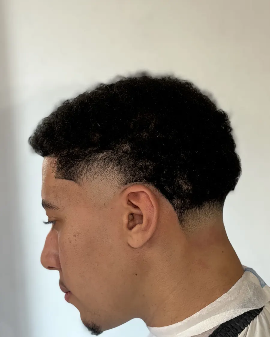 Degradado bajo con pelo rizado arriba, visto de perfil